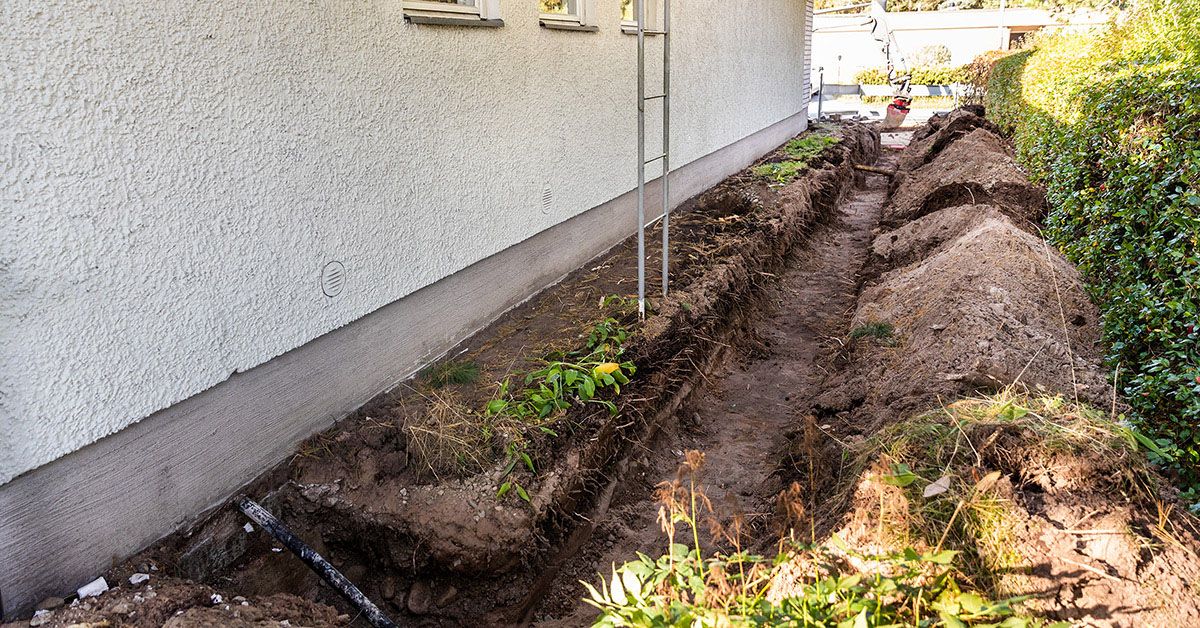 Kaivuutyömaa puutarhassa, eli kaukolämpöputkelle kaivettu ura nurmikon poikki taloon.
