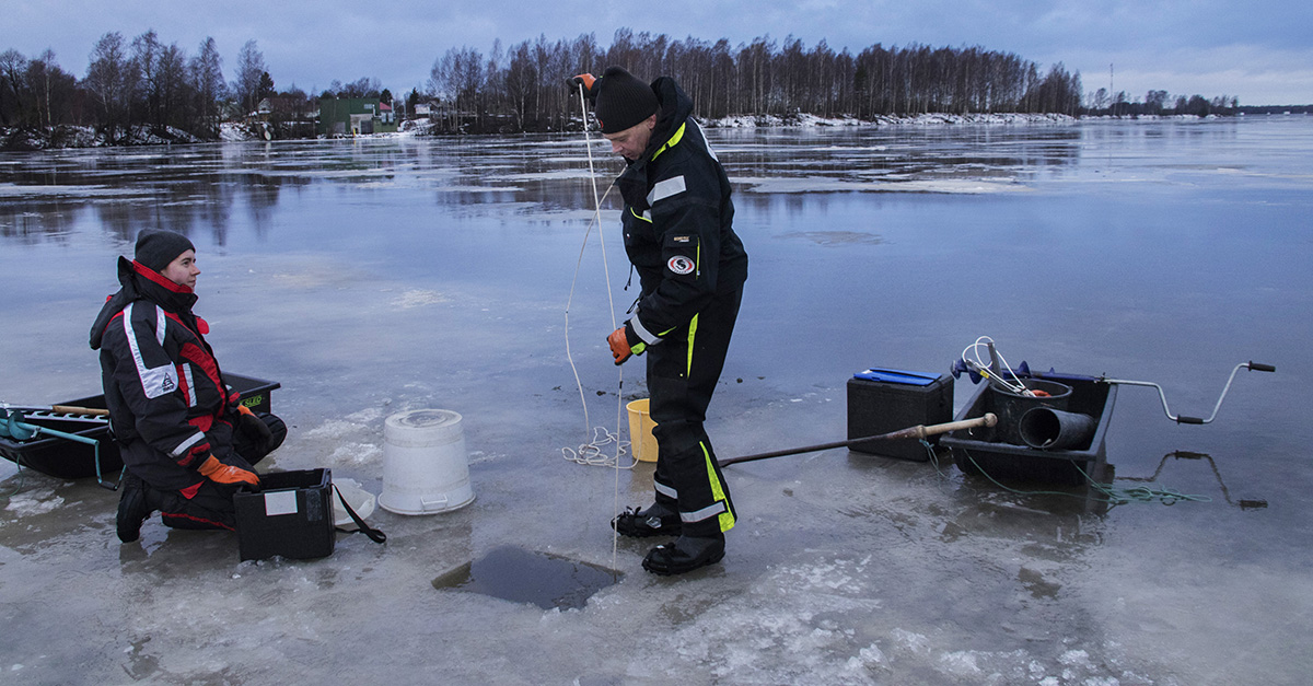 Näytteenottoputki lasketaan köyden avulla joen pohjaan.