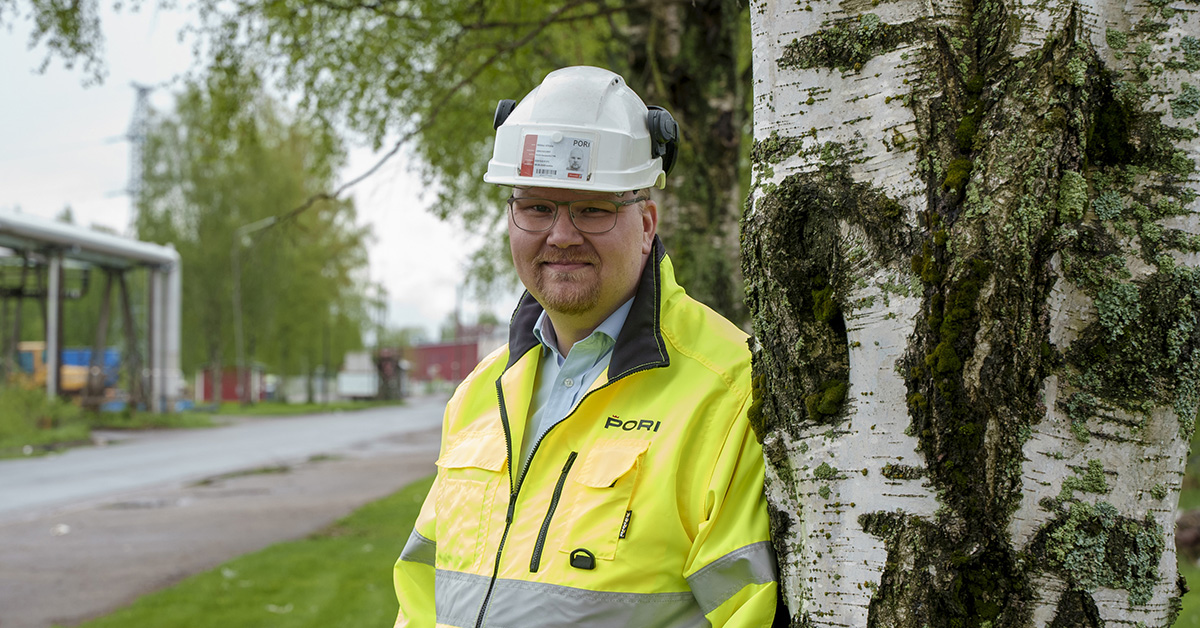 Mikko Viitala työvaatteissa nojaa koivuun